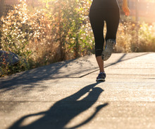 A Woman Running On A City Sidewalk.