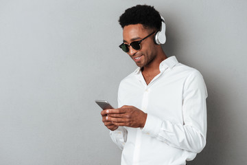 Sticker - Happy young african man in sunglasses listening music