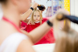 Little girl make a hairstyle in the beauty salon.