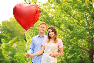 Poster - Lovely couple with heart shaped balloon in park on sunny day