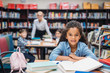 © LIGHTFIELD STUDIOS - schoolgirl with pile of books at library