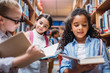 © LIGHTFIELD STUDIOS - schoolgirls looking for books in library