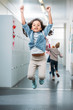 © LIGHTFIELD STUDIOS - girl jumping in school corridor