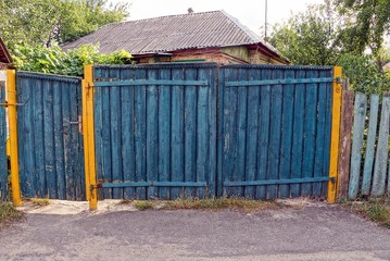 Wall Mural - сельский синий деревянный забор и закрытые двери на улице у дороги 