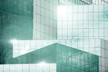 Blue sky and clouds reflecting in windows of modern office building