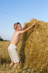 Boy Climbing a Bale of Hay