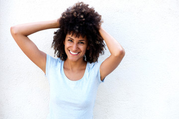 Wall Mural - Cheerful woman standing with hands in curly hair