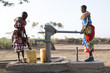 © Hugh Sitton - Samburu tribal women collecting fresh water from well in desert landscape. Kenya, Africa.
