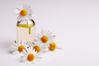 Chamomile essential oil on a white acrylic background