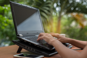 Poster - woman's hands on keyboarding while working messaging  via social networks using computer laptop. background of nature