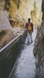 Hombre joven haciendo una ruta de senderismo entre unas montañas rocosas