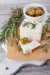 Wall Mural - Fresh feta cheese with rosemary on white wooden serving board