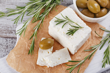 Wall Mural - Fresh feta cheese with rosemary on white wooden serving board