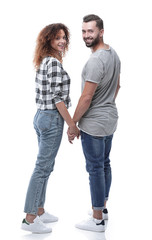 Rear view of happy couple holding hands and looking at camera