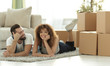© ASDF - concept of moving to a new home. Happy couple lying on the floor