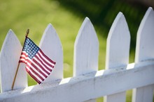 American Flag On White Picket Fence