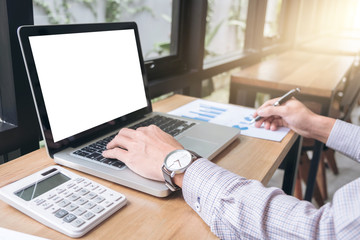 Poster - Elegant businessman working on his laptop in a coffee shop, analyzing data and graph, using calculator calculate, young man typing on computer sitting at wooden table