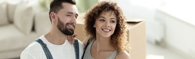 Happy couple on the background of a new apartment.