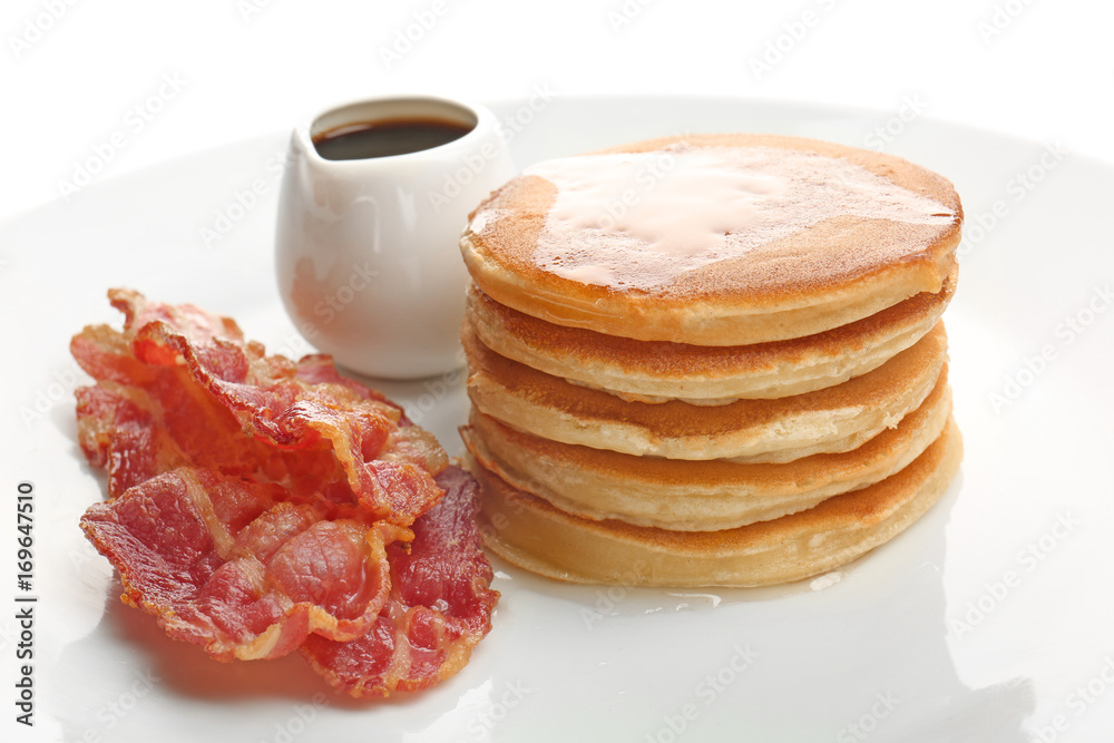 Tasty pancakes and bacon on white background