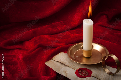 Fotografia, Obraz Masonic secrecy concept with a lit candle on a letter made of old vintage paper