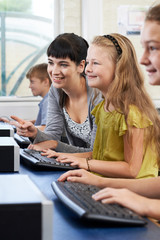 Wall Mural - Female Elementary Pupil In Computer Class With Teacher