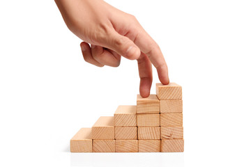 Hand liken business person stepping up  toy staircase