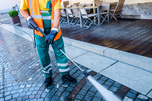 Cuadros en Lienzo Worker cleaning the cobbled street in Ljubljana, Slovenia.