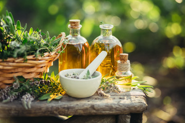 spa composition with fresh herbs and different types of oils.