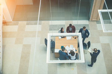 High angle view of multi-ethnic business people discussing in board room meeting