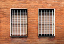 Window Bars And Closed Windows On A Bricks Wall