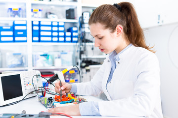 Canvas Print - Young woman in electronics repair service center