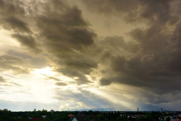 Wall Mural - blue cloudy sky over the city with golden sun ray at dusk