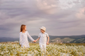 Happy kids on the field of chamomiles