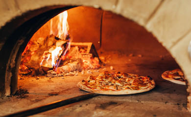 Italian pizza is cooked in a wood-fired oven.