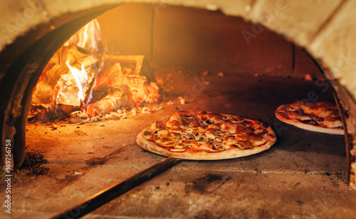 Italian pizza is cooked in a wood-fired oven.