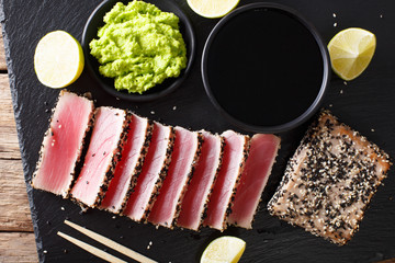 Wall Mural - Fresh tuna meat in sesame and soy sauce, wasabi, lime closeup. Top view horizontal