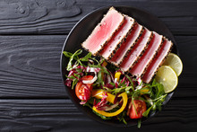 Close Up Of Rare Seared Ahi Tuna Slices With Fresh Vegetable Salad. Top View Horizontal