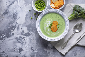 Canvas Print - Composition with broccoli soup with rucks on grey background