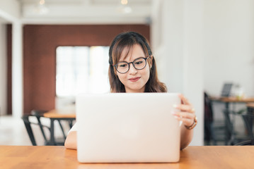 Wall Mural - Asian young business freelance woman happiness working online business with laptop and cell phone in cafe shop. Working, Success, happiness concept.