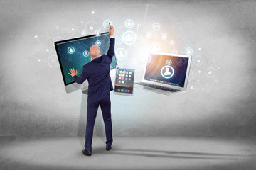 Poster - businessman in front of a wall with computer and devices displayed on a futuristic interface with bu