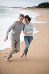 Canvas Print -  a young couple walking on the beach