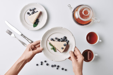 Wall Mural - woman serving cheesecake with blueberries on table