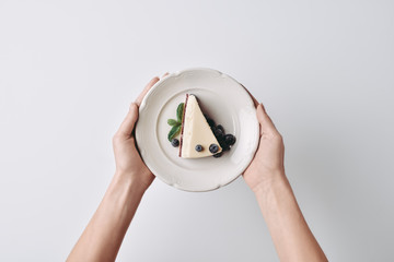 Wall Mural - woman holding slice of cheesecake