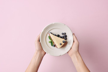Wall Mural - woman holding slice of cheesecake