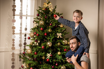 family decorating christmas tree together