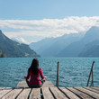 Meditation, self-reflection. Woman meditating sitting on the lake shore. 