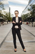 © xo4uphoto - Business woman in suit standing outdoors at the street