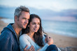 © jackfrog - Beautiful couple sitting at the beach watching the sunset