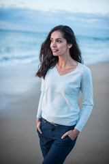 Wall Mural - Portrait of a brunette with long hair walking on the beach