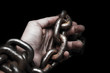 victim, slave, prosoner male hands tied by big metal chain by him self. People have no freedom concept image.